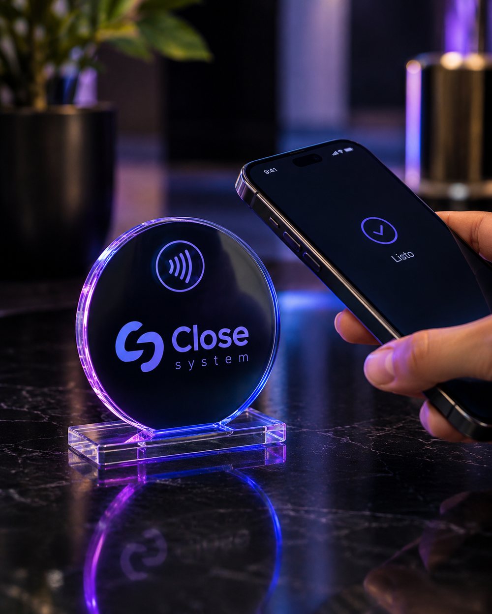 Un celular tocando un módulo Close System sobre una mesa oscura